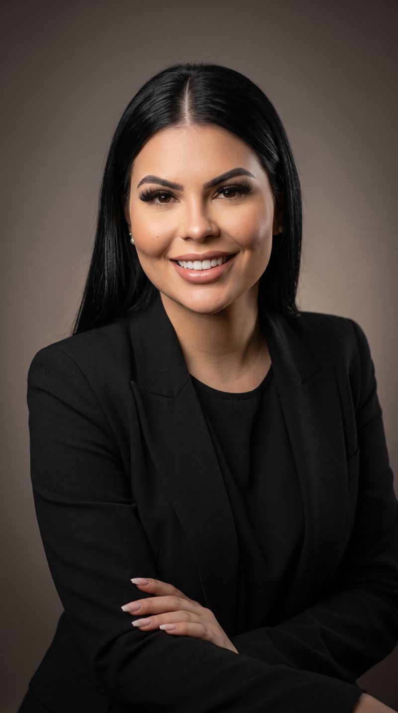 Retrato da Dra. Carolina Vasconcelos, de blazer preto e braços cruzados